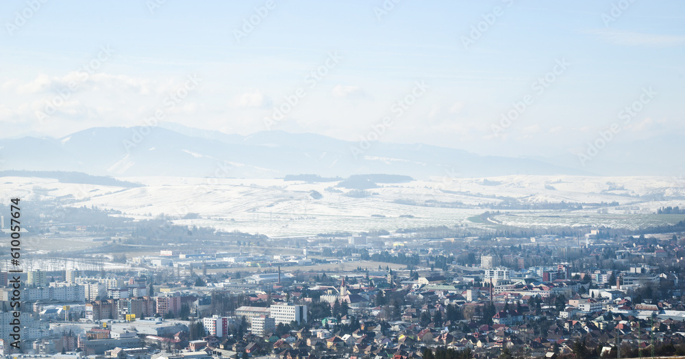 View from hill Nicovo to the part of Liptovsky Mikulas city in the winter and to Low tatras. Slovakia, Liptov region. Snowy, cold and sunny weather.