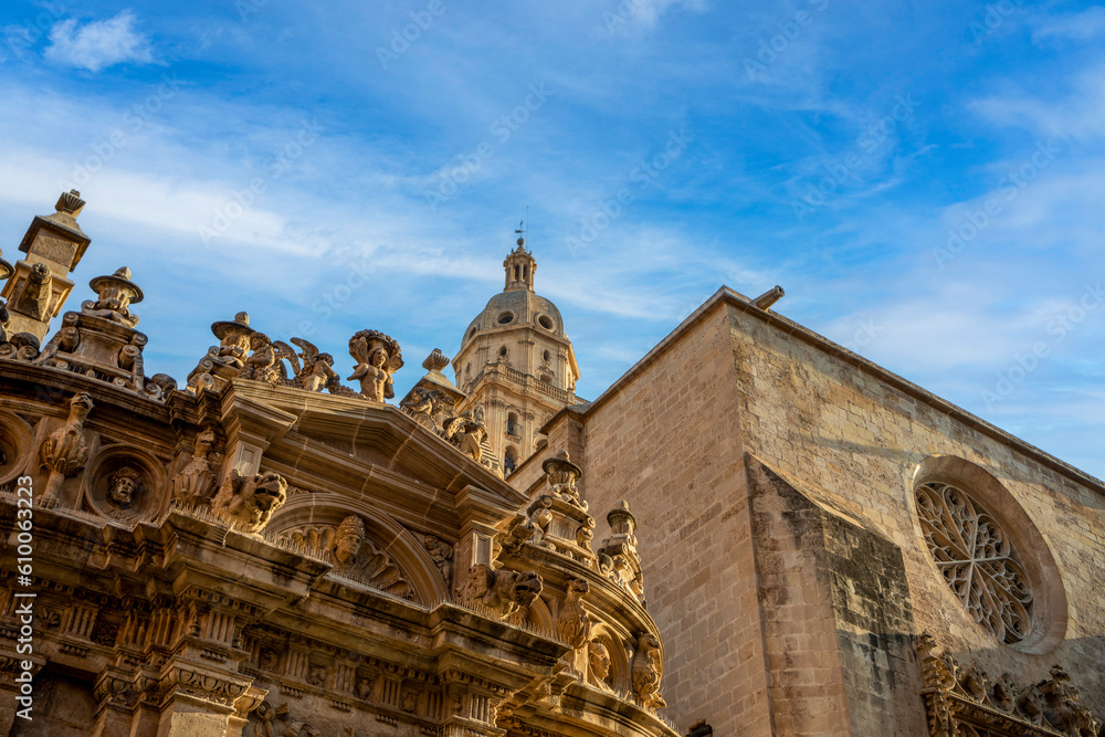View of the south façade of the Cathedral of Santa Maria in Murcia, Spain with recognizable Renaissance and Gothic styles and the bell tower in the background