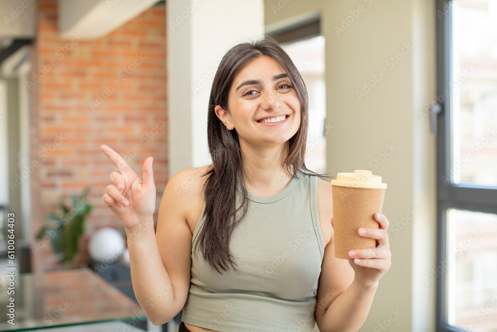 young woman smiling cheerfully, feeling happy and pointing to the side. take away coffee young woman smiling cheerfully, feeling happy and pointing to the side. take away coffee