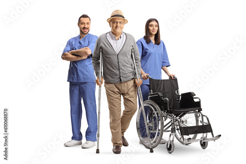 Male and female nurse standing behind a senior man with crutches