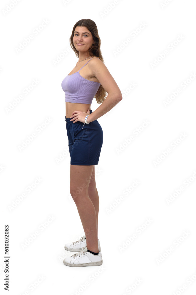 side view of a young girl standing ,looking at camera and hands on the hip on white background side view of a young girl standing ,looking at camera and hands on the hip on white background
