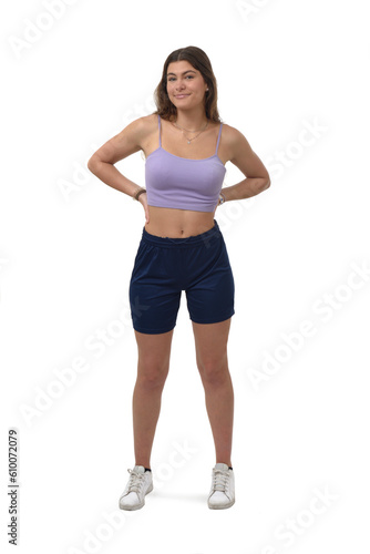 front view of a young girl standing with arm akimbo and looking at camera on white background