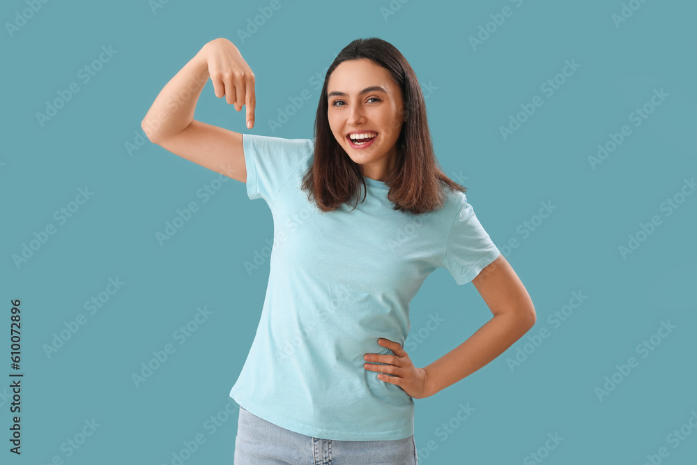Young woman pointing at something on blue background Young woman pointing at something on blue background