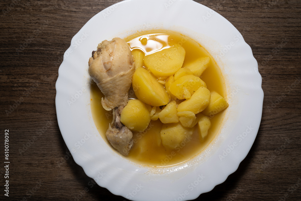 Potato soup with chicken drumsticks in plate and wooden background Potato soup with chicken drumsticks in plate and wooden background