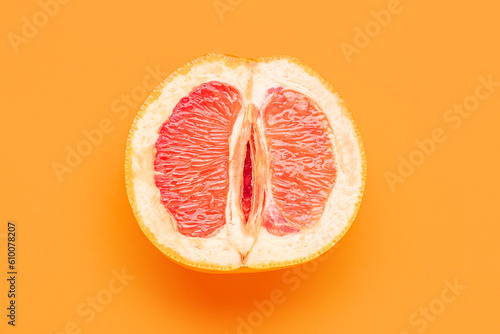 Half of grapefruit on orange background. Sex concept
