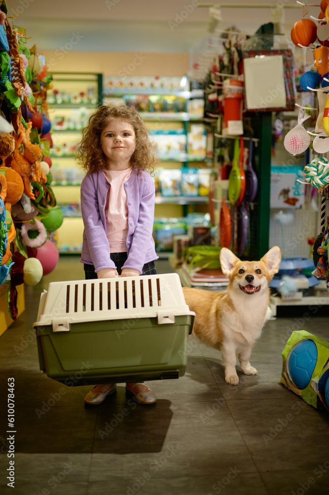 Portrait of little girl with her corgi dog at pet shop