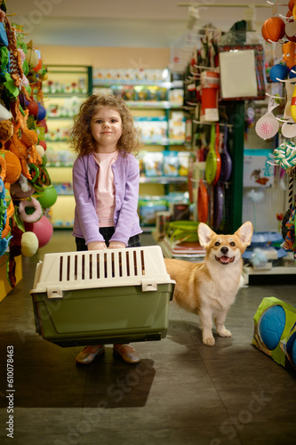 Portrait of little girl with her corgi dog at pet shop © Nomad_Soul