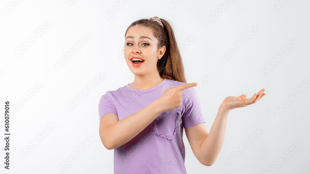 Lovely smiling young woman with long hair pointing finger right, showing advertisement, promo offer, standing in casual t shirt over white background Lovely smiling young woman with long hair pointing finger right, showing advertisement, promo offer, standing in casual t shirt over white background