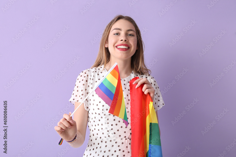 Young woman with LGBT flags on lilac background Young woman with LGBT flags on lilac background