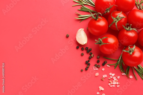 Composition with ripe cherry tomatoes, rosemary, sea salt and peppercorn on red background