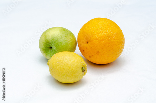 Orange green-apple and lemon on white