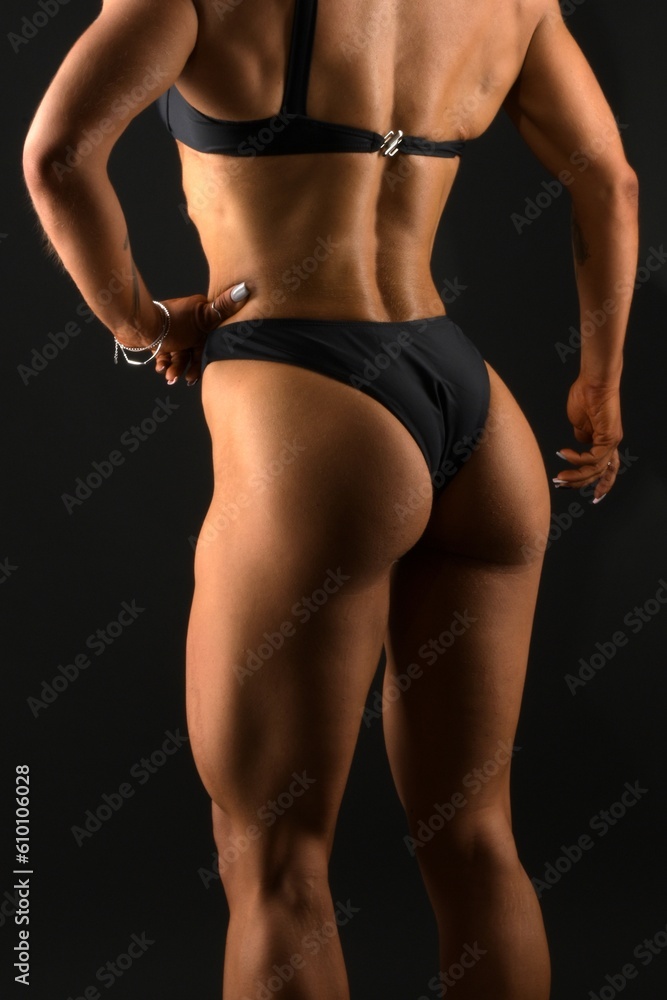 The body of a young athletic girl on a dark background The body of a young athletic girl on a dark background