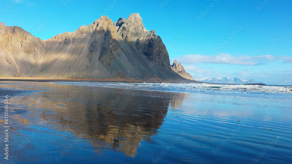 Massive mountain range meeting the ocean, beautiful icelandic landscapes with black sand beach. Arctic stokksnes peninsula with vestrahorn mountains and ocean coastline, sightseeing. Massive mountain range meeting the ocean, beautiful icelandic landscapes with black sand beach. Arctic stokksnes peninsula with vestrahorn mountains and ocean coastline, sightseeing.