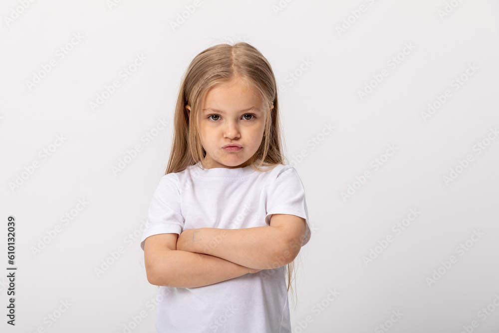Negative human emotions, reactions and feelings. Isolated shot of moody displeased angry little girl crossing arms on her chest, pouting lips, having offended facial expression, being capricious Negative human emotions, reactions and feelings. Isolated shot of moody displeased angry little girl crossing arms on her chest, pouting lips, having offended facial expression, being capricious