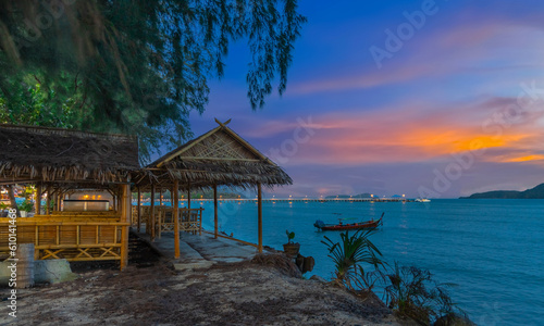 Sunset over Rawai Beach in Phuket island Thailand. Lovely turquoise blue waters, lush green mountains colourful skies and beautiful views the pier and long tail boats. Sky is taken seperate from Body 