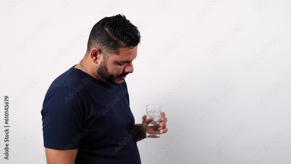 un hombre en fondo blanco tomando agua con hielo - Un hombre se deleita con un sorbo de agua fría - Un momento de tranquilidad con un hombre bebiendo agua con hielo - La pureza del agua