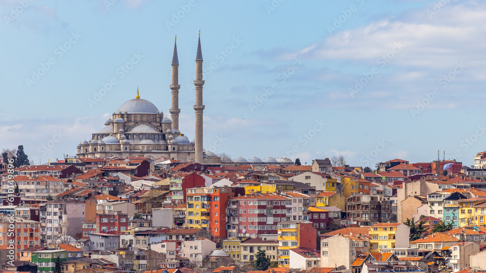 Fototapeta premium Suleymaniye mosque with colorful residential house area in Istanbul with blue sky background, Turkey, Istanbul Mosque Suleymaniye minaret with colorful house, Beautiful view Istanbul, Turkiye.