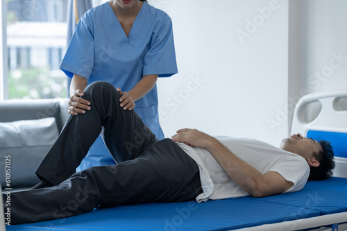 A physiotherapist or medical professional is doing counseling and physiotherapy on the knee and leg area at the patient's injured ward. stretching exercise causes pain, health insurance