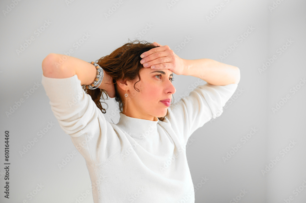 Unhappy woman with headache touching her hair in the office. Depressed frustrated young girl with migraine. Stressed young housewife. Unhappy woman with headache touching her hair in the office. Depressed frustrated young girl with migraine. Stressed young housewife.