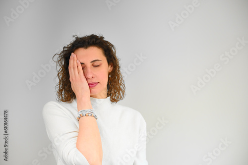 Unhappy woman with headache touching her hair in the office. Depressed frustrated young girl with migraine. Stressed young housewife.