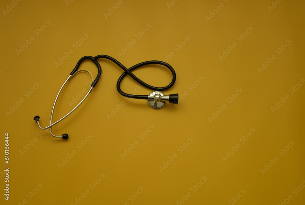 Top shot of stethoscope on ocher background - health check up concept Top shot of stethoscope on ocher background - health check up concept