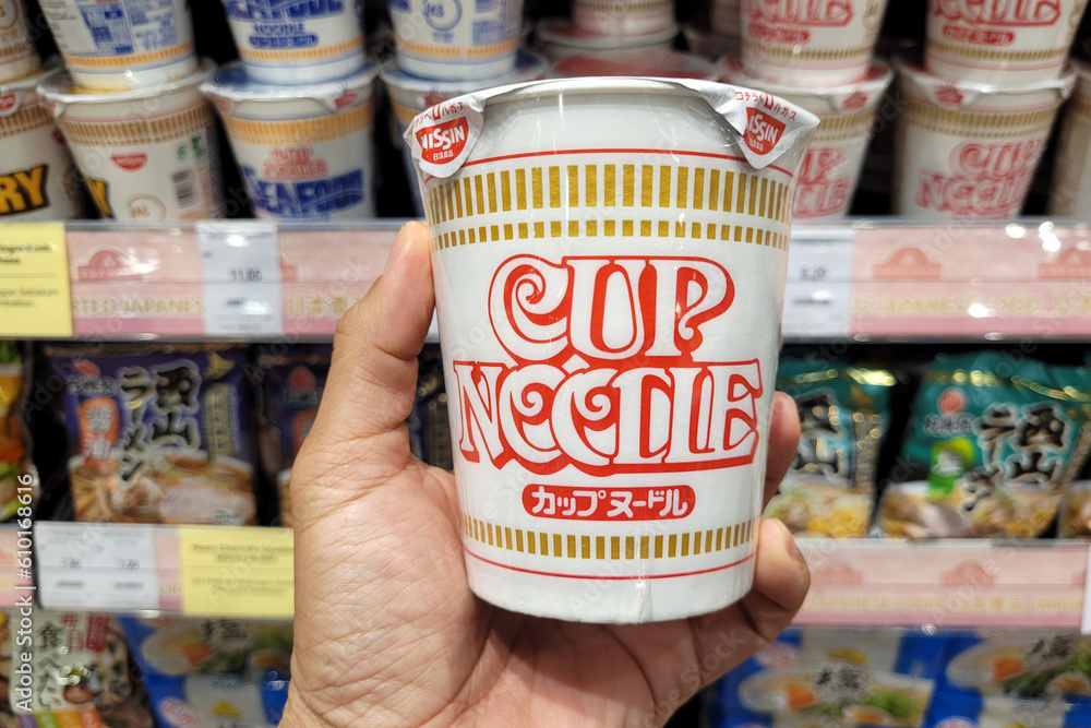 PENANG, MALAYSIA 26 MAY 2023 Hand holding a Nissin brand Cup noodle