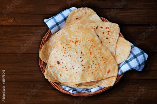 Triangle shape Plain Parotha or namak Parantha or tel paratha is an Indian flatbread made of whole-wheat flour, salt, and oil. served in a wooden basket. copy space.