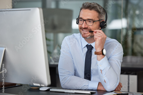 Businessman, call center and smile with headphones on computer in customer service, telemarketing or support at office. Man, consultant or agent consulting for online advice or telesales at workplace photo
