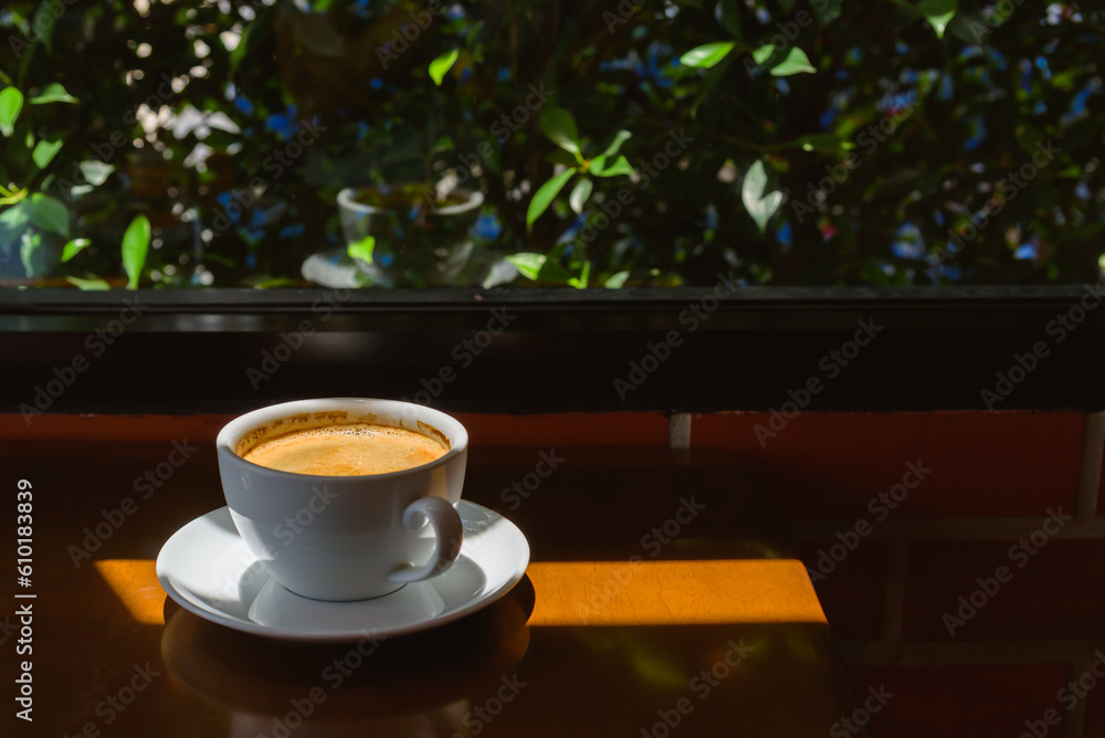 Fototapeta premium Coffee cup in morning light, sunlight shadow, morning coffee breakfast concept.