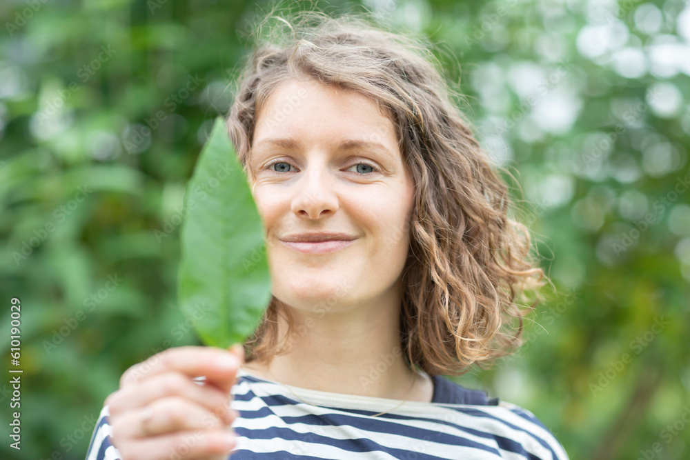 young woman with green leave in the hand young woman with green leave in the hand