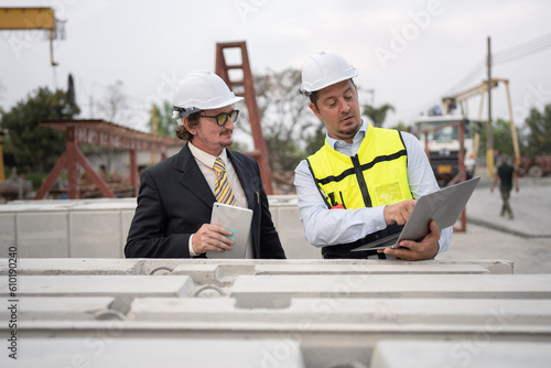 Portrait two caucasian engineer man working with notebook computer at precast site work 