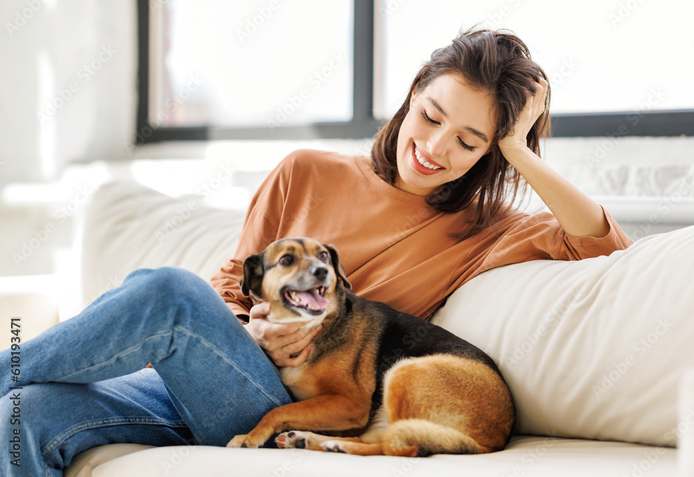 cheerful woman hugging her beloved pet dog at home on the couch. cheerful woman hugging her beloved pet dog at home on the couch.