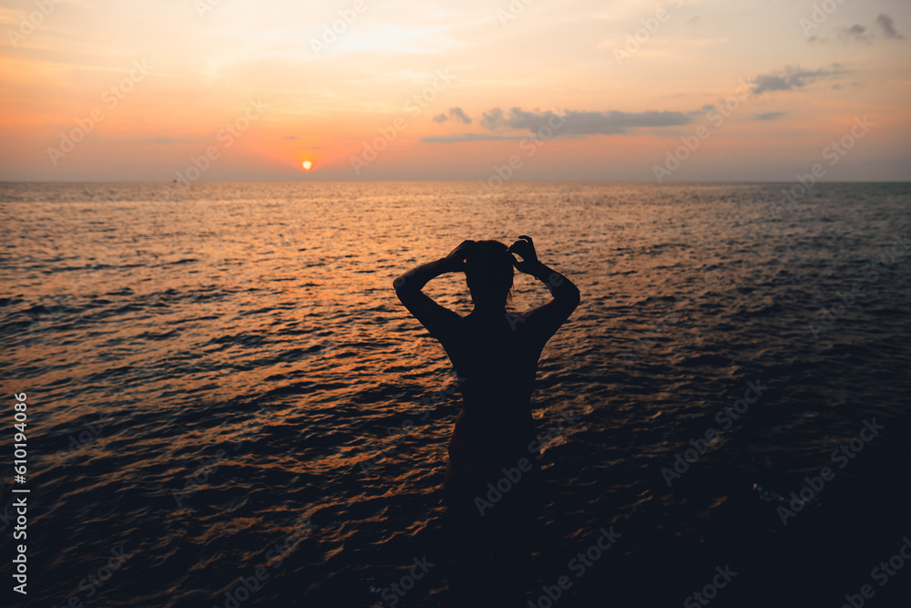 Fototapeta premium Sunset and Clouds over the Ocean,Woman watching the sun set