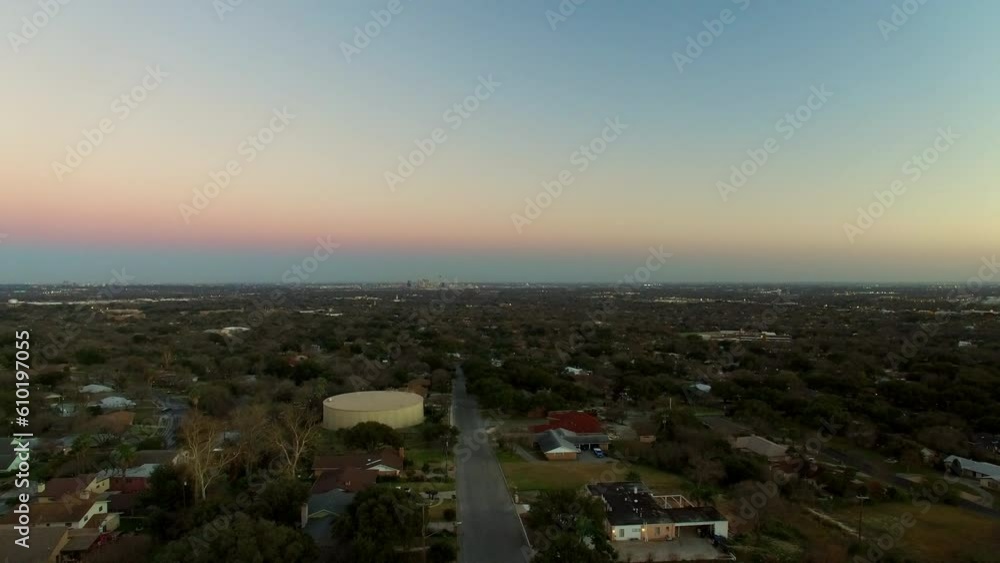 Aerial Shot Of Houses Amidst Trees In Suburb At Sunset, Drone Descending Forward Over Neighborhood Against Sky - San Antonio, Texas Aerial Shot Of Houses Amidst Trees In Suburb At Sunset, Drone Descending Forward Over Neighborhood Against Sky - San Antonio, Texas