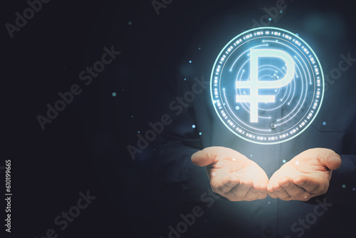 Close up of male hand holding digital round ruble sign on dark background with blurry mock up place. Online banking, cryptocurrency and finance concept.