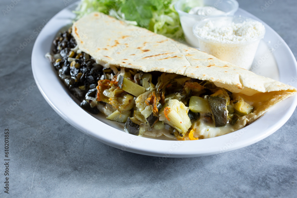 A view of a quesadilla, featuring huitlacoche and flor de calabaza. A view of a quesadilla, featuring huitlacoche and flor de calabaza.