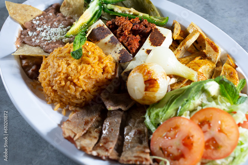 A view of a Mexican platter, featuring chorizo, cecina, tasajo, pollo. photo