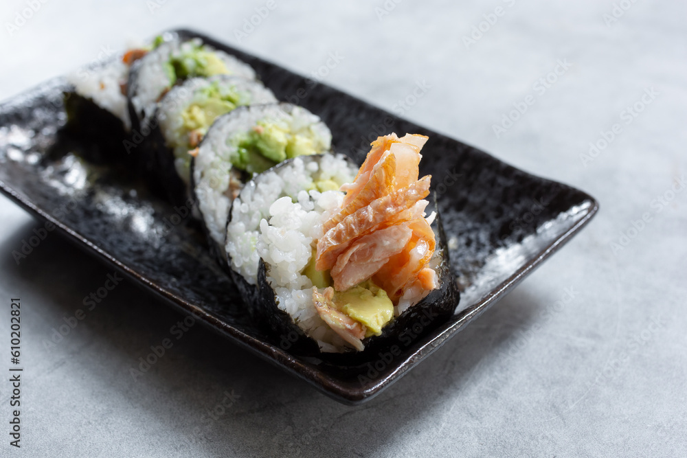 A closeup view of a plate of salmon skin roll. A closeup view of a plate of salmon skin roll.