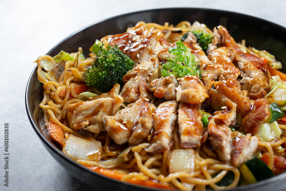 A closeup view of a bowl of chicken yakisoba noodles. A closeup view of a bowl of chicken yakisoba noodles.