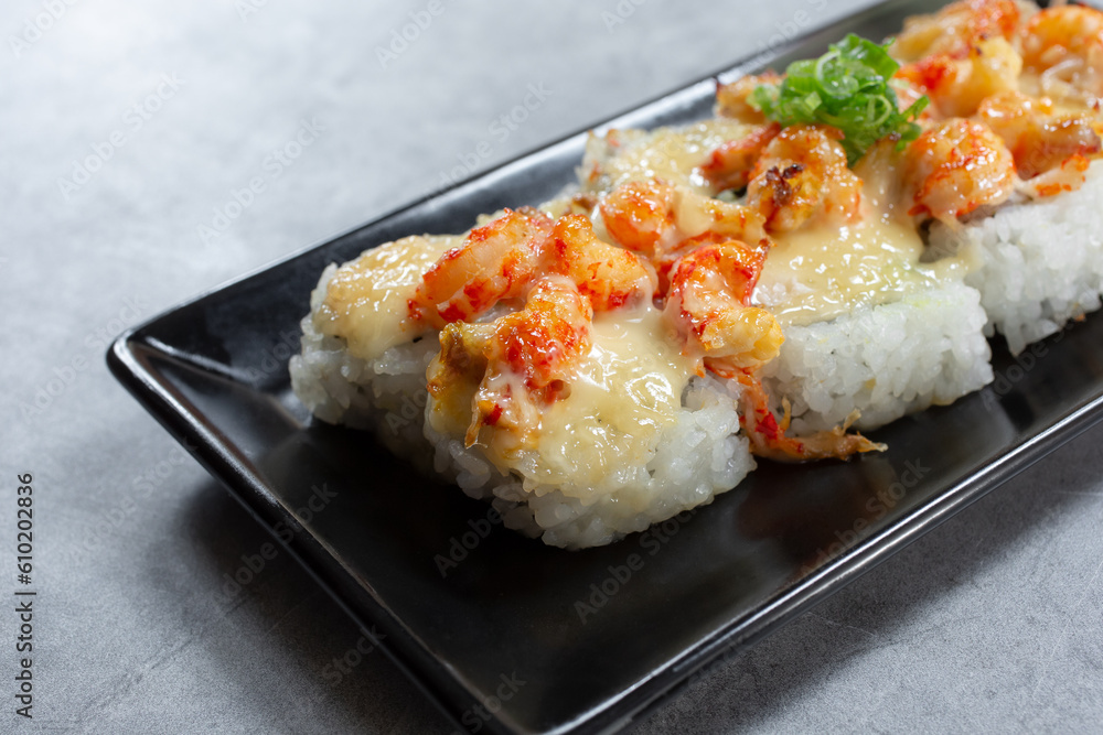 A closeup view of a plate of baked lobster roll. A closeup view of a plate of baked lobster roll.