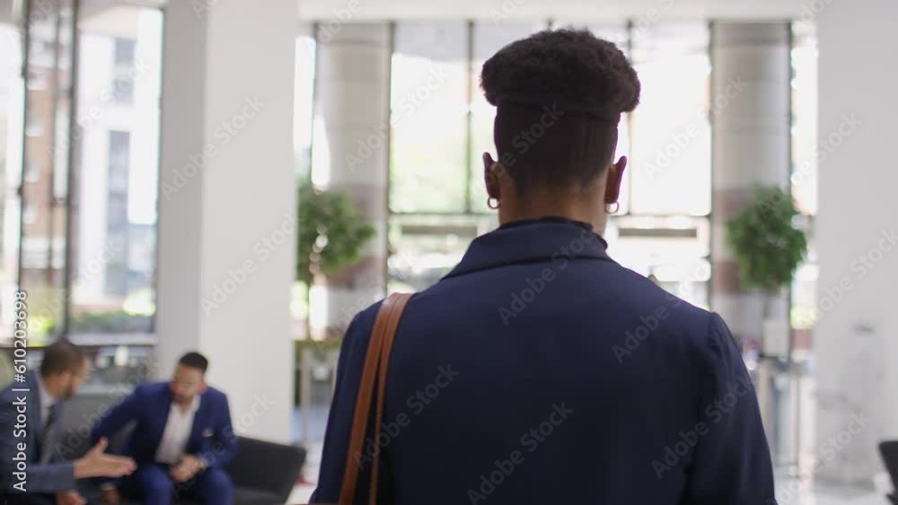 Professional black female exits a lift using her phone and walks through a building lobby Professional black female exits a lift using her phone and walks through a building lobby