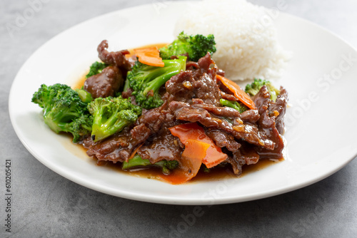 A view of a plate of beef broccoli and steamed white rice.