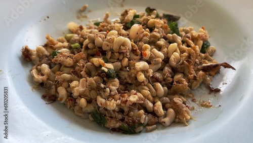 ant eggs spicy salad in white dish (yum khai mod daeng)