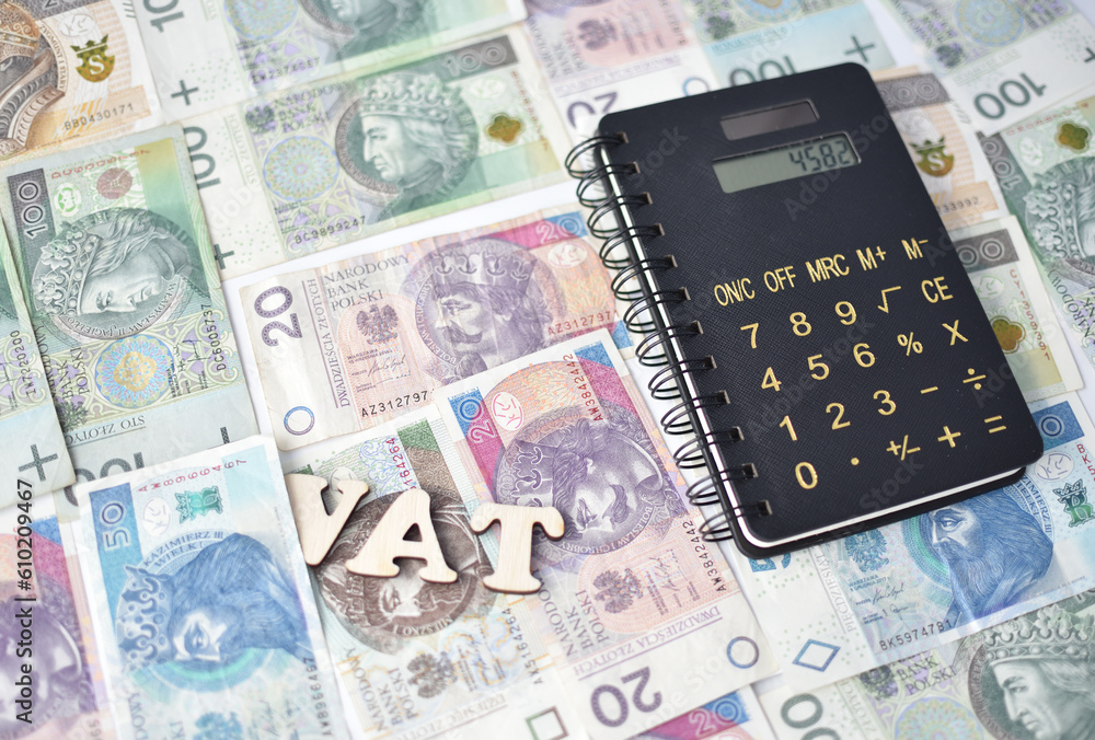 Napis VAT, kalkulator, a w tle rozne banknoty, zlotowki o roznych nominalach. Napis VAT, kalkulator, a w tle rozne banknoty, zlotowki o roznych nominalach.