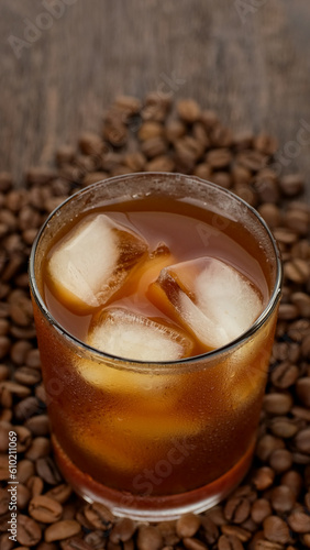 Pouring black coffee in glass with ice. Making iced coffee