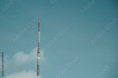 A cell phone tower with a dark sky behind it.