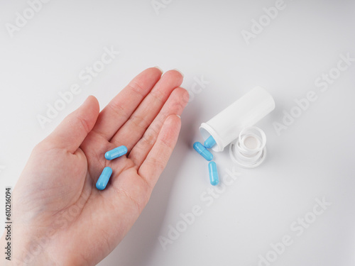 blue pills in hand on white background
