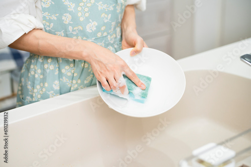 Fotobehang 皿洗いをする若い女性　ライフスタイルイメージ