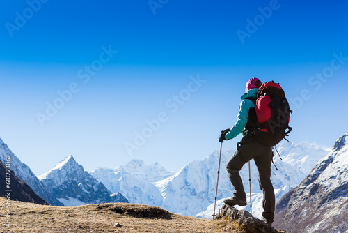 Woman Traveler with Backpack hiking in Mountains with beautiful Himalaya landscape on background mountaineering sport lifestyle concept