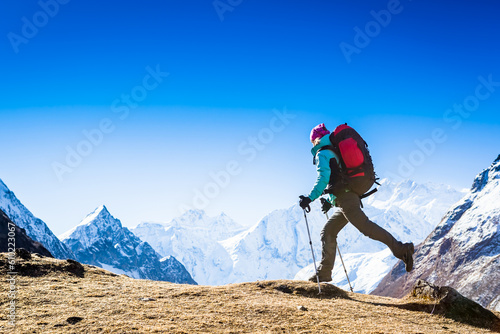 Woman Traveler with Backpack hiking in Mountains with beautiful Himalaya landscape on background mountaineering sport lifestyle concept
